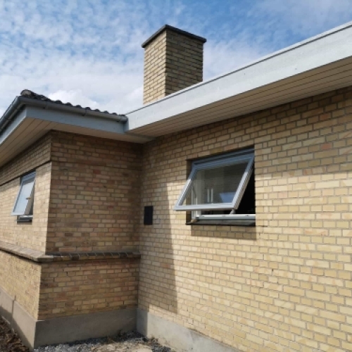 Renovering af facade med nye vinduer og opdateret tagudhæng