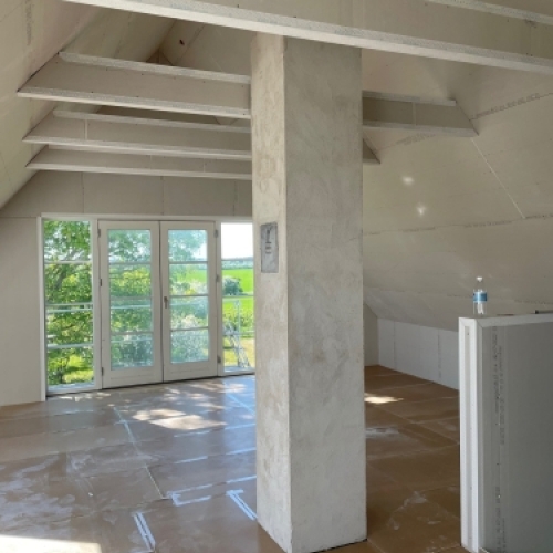 Indvendig tilbygning til hus med loft til kip, store vinduer og nyt rum