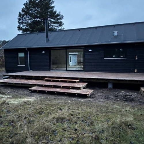 Nyt tag på sort træhus med moderne tagdækning og terrasse