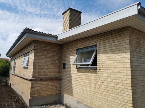 Renovering af facade med nye vinduer og opdateret tagudhæng