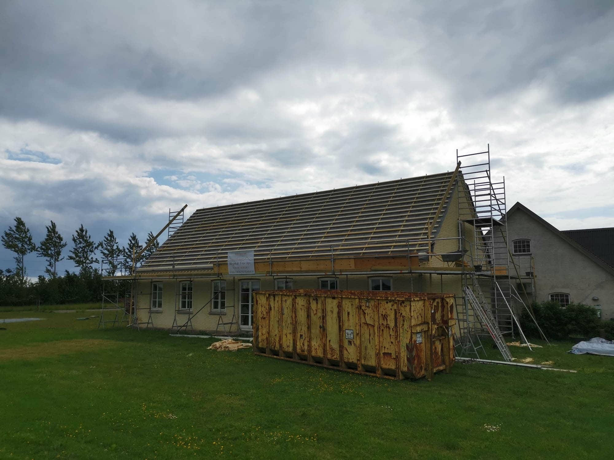 Nybyggeri under opførelse med tagkonstruktion og stillads på større bolig